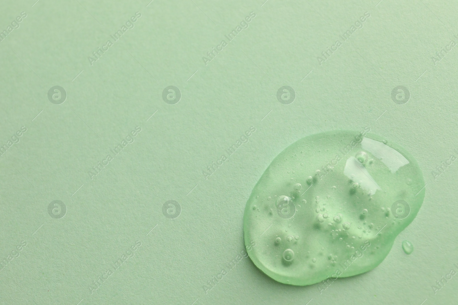 Photo of Sample of face gel on light green background, top view. Space for text