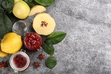 Photo of Delicious quince jam and fruits on grey table, flat lay. Space for text