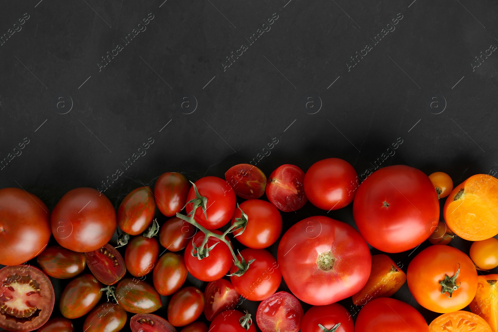 Photo of Flat lay composition with fresh ripe tomatoes on black background. Space for text