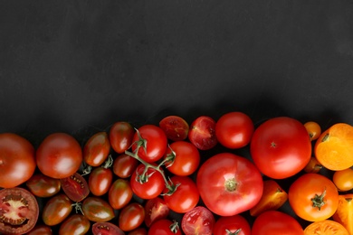 Flat lay composition with fresh ripe tomatoes on black background. Space for text