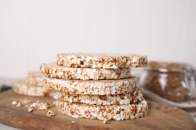 Photo of Stack of fresh crunchy rice cakes on wooden board, closeup