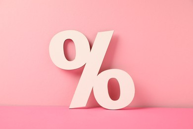 Photo of White wooden percent sign on pink background