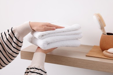 Photo of Bath accessories. Woman with stack of clean towels indoors, closeup