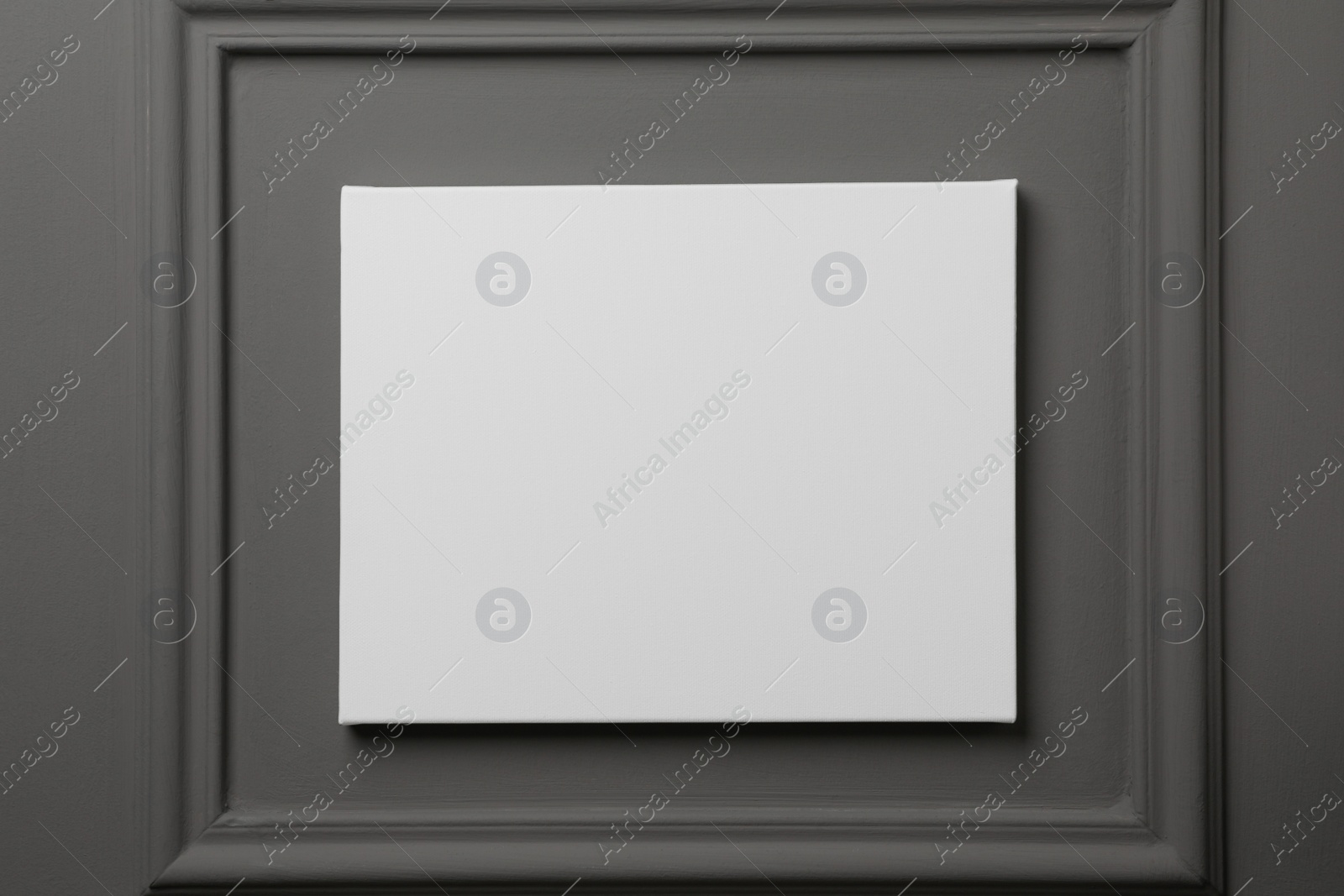 Photo of Blank canvas hanging on grey wall, space for text