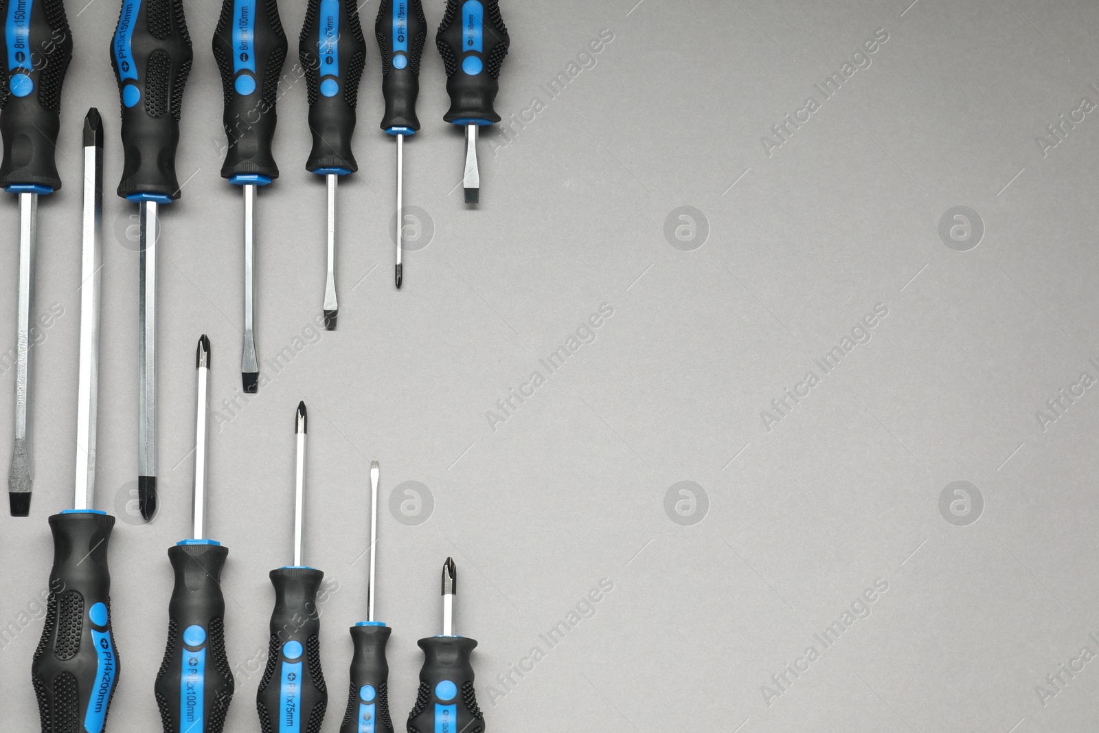 Photo of Set of screwdrivers on grey background, flat lay. Space for text