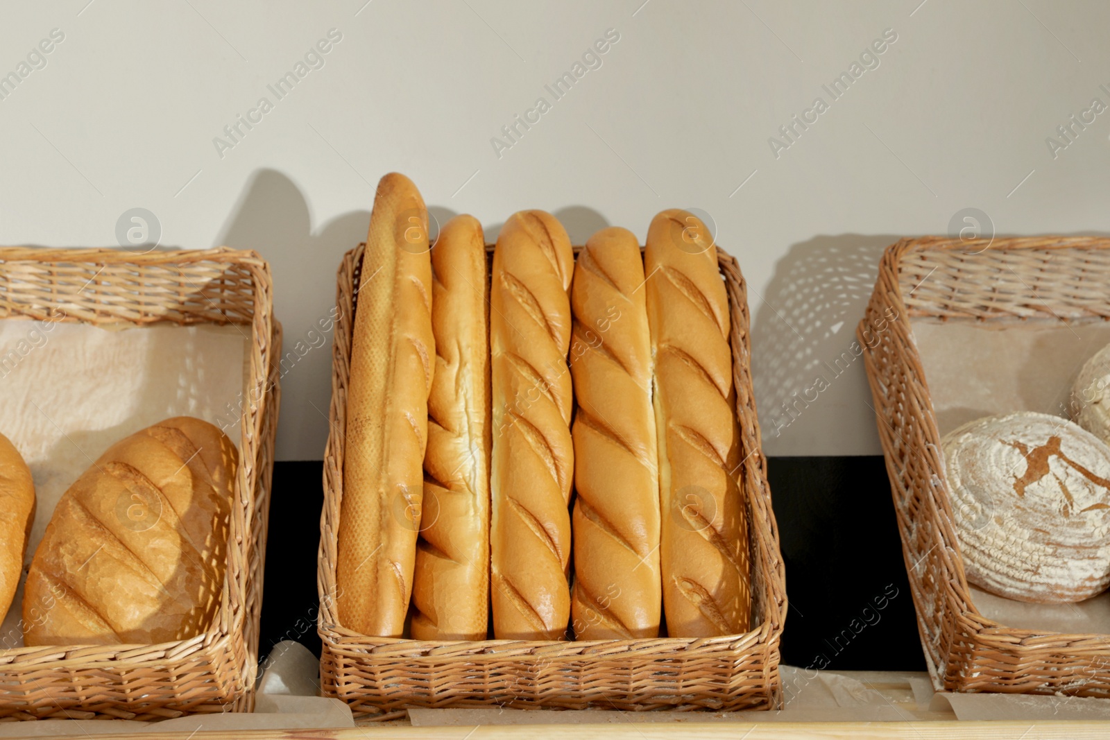 Photo of Trays with different breads on shelf in bakery