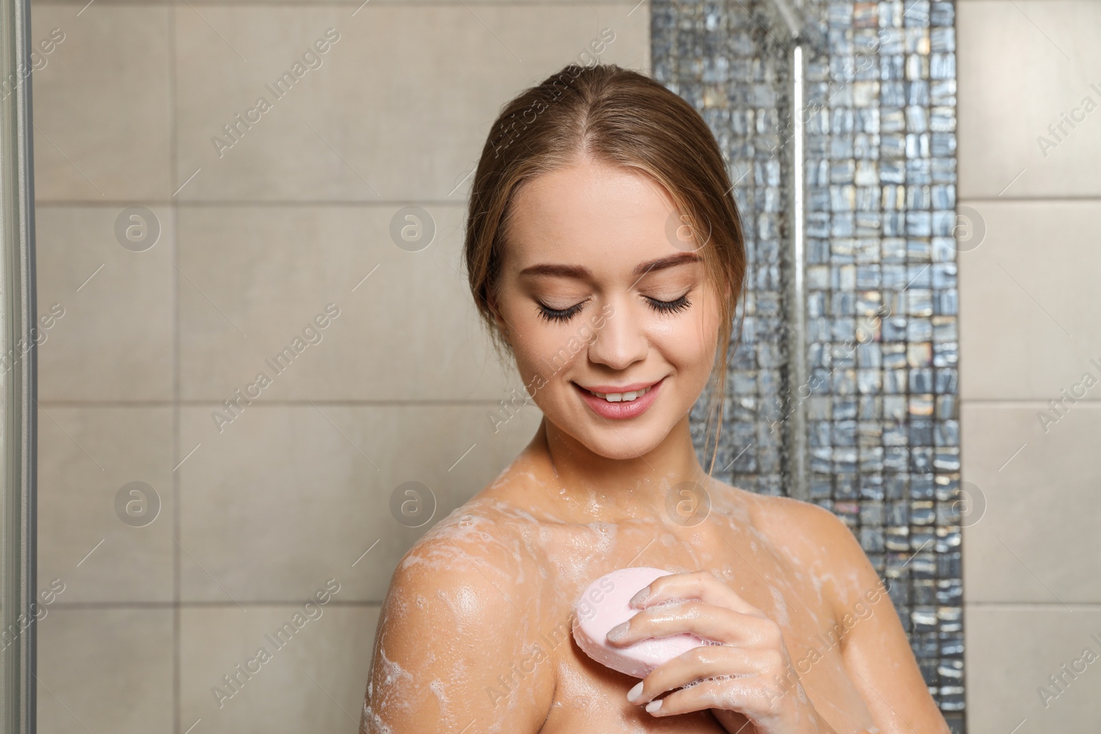 Photo of Beautiful young woman taking shower with soap in bathroom. Space for text