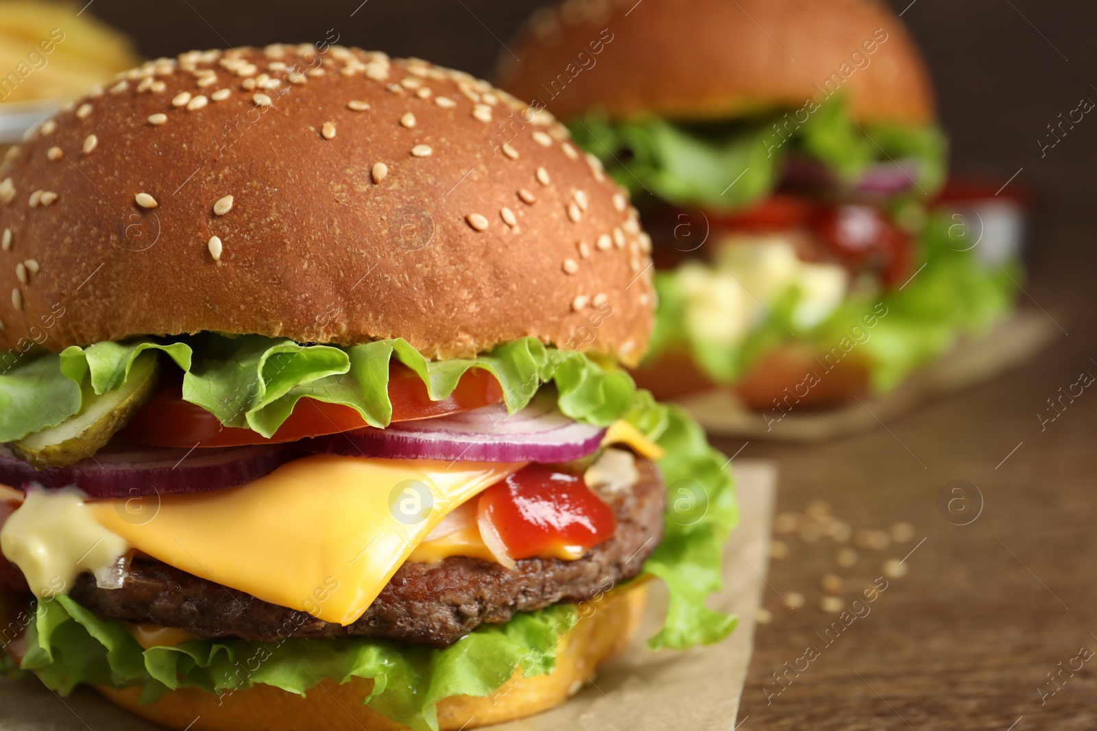 Photo of Delicious burgers with beef patty and lettuce on table, closeup. Space for text