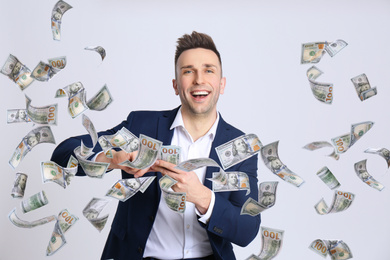 Image of Happy young man with money on light background