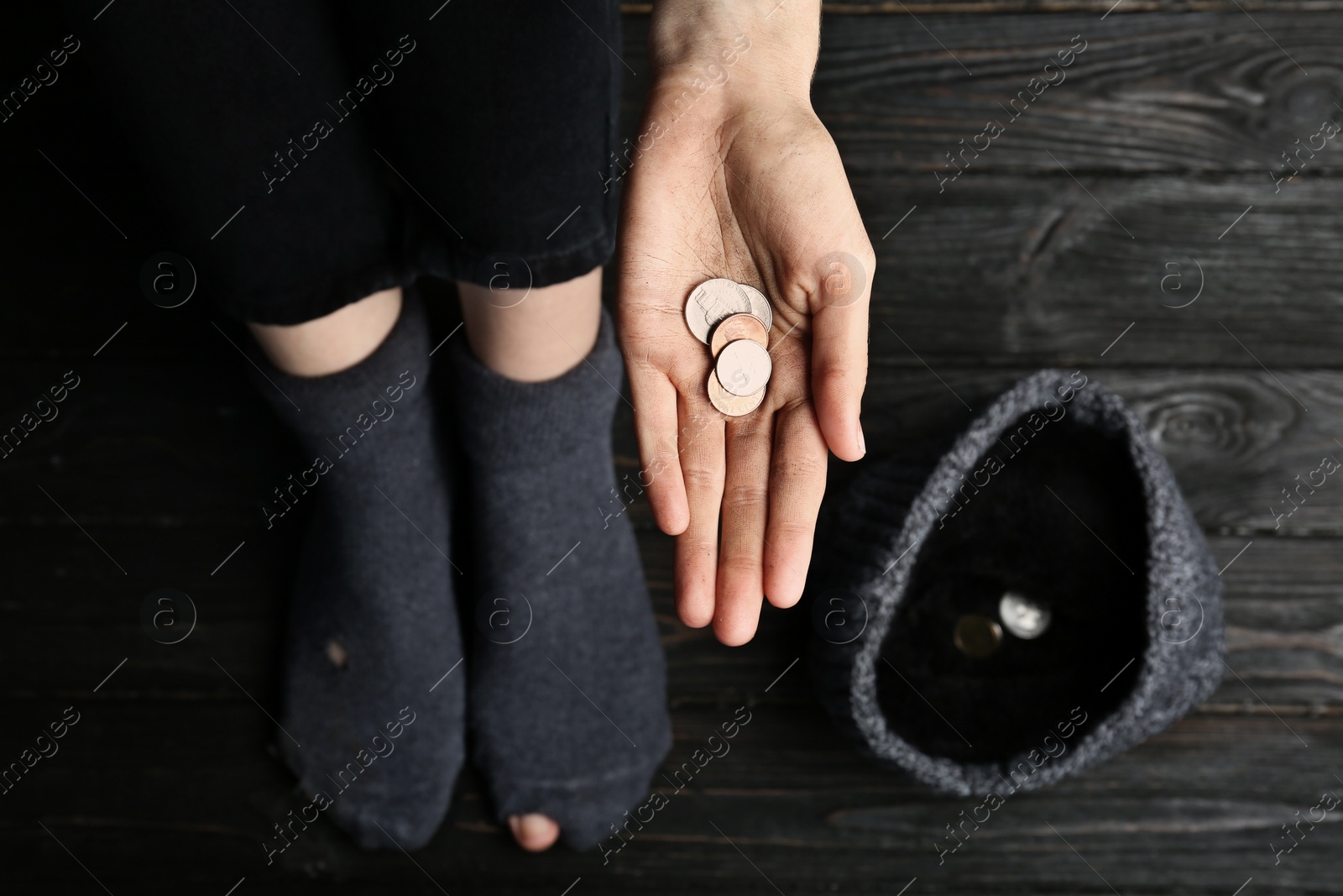 Photo of Poor woman in shabby socks begging for money, closeup of hand with coins