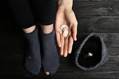 Photo of Poor woman in shabby socks begging for money, closeup of hand with coins