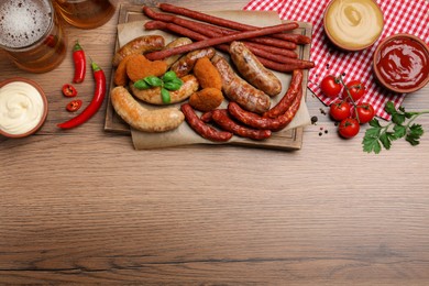 Photo of Set of different tasty snacks and beer on wooden table, flat lay. Space for text