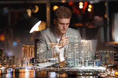 Image of Double exposure of young man working in office and night cityscape. Financial analytics