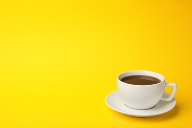 Photo of White ceramic cup with hot aromatic coffee on color background