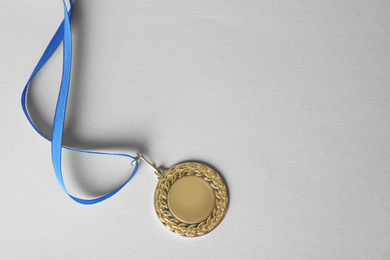 Photo of Gold medal on white background, top view. Space for design