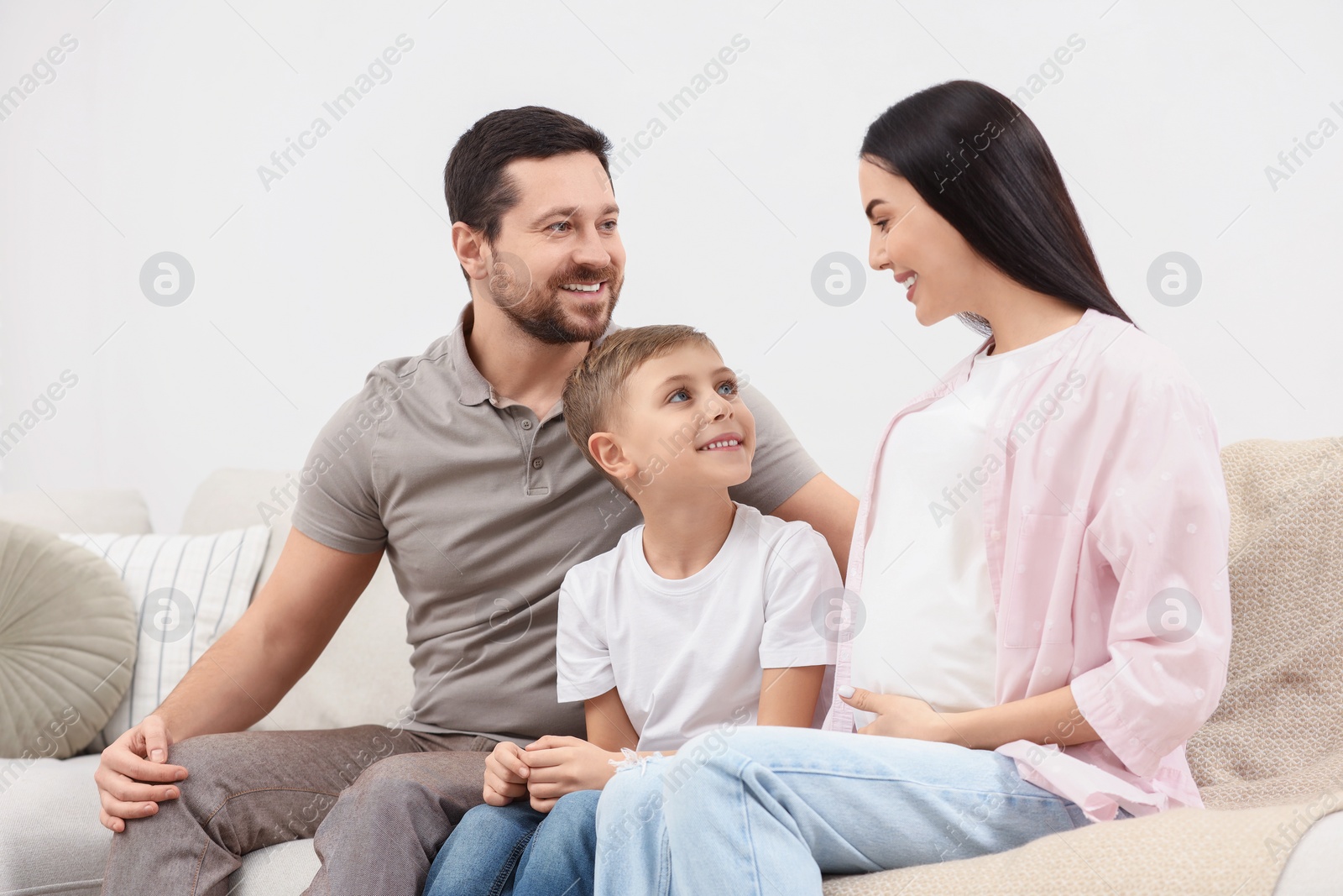 Photo of Happy pregnant woman spending time with her son and husband at home