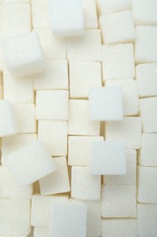 Photo of White sugar cubes as background, top view