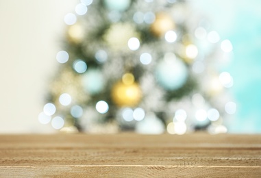 Photo of Empty wooden table and blurred fir tree with Christmas lights on background, bokeh effect. Space for design