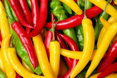 Photo of Ripe hot chili peppers as background, closeup