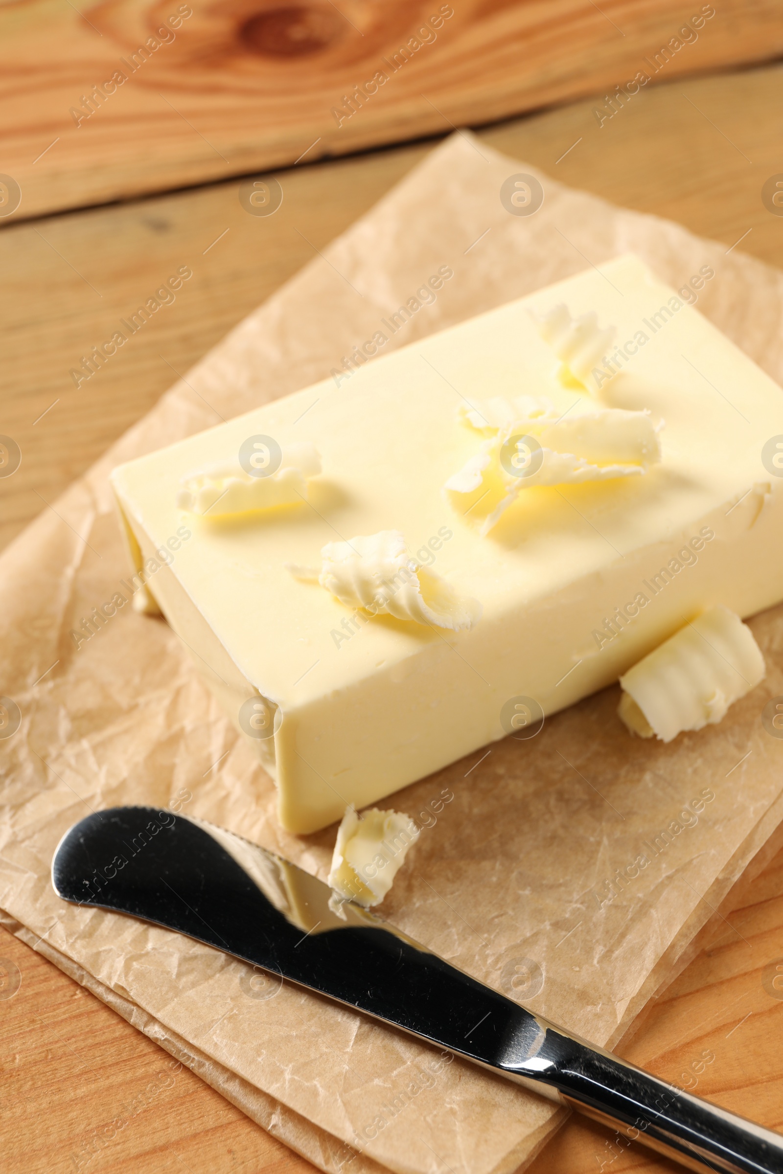 Photo of Tasty butter and knife on wooden table