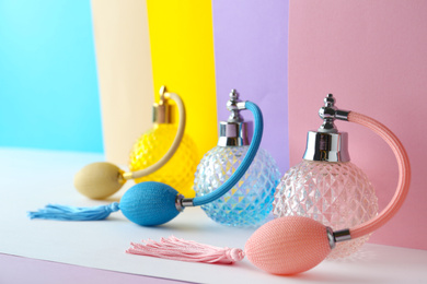 Photo of Composition with different bottles of perfume on color background, closeup