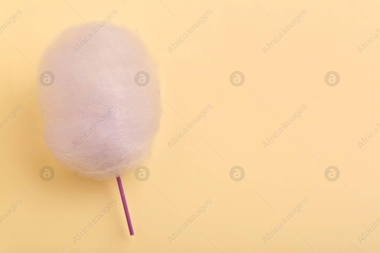 Photo of One sweet cotton candy on beige background, top view. Space for text