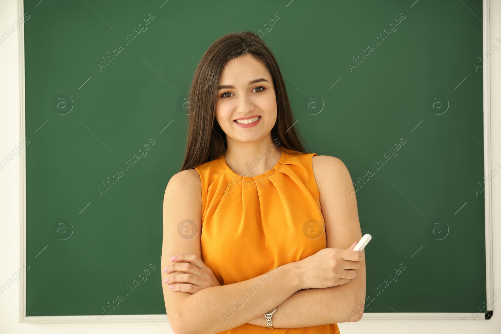 Photo of Portrait of female teacher near blackboard in classroom