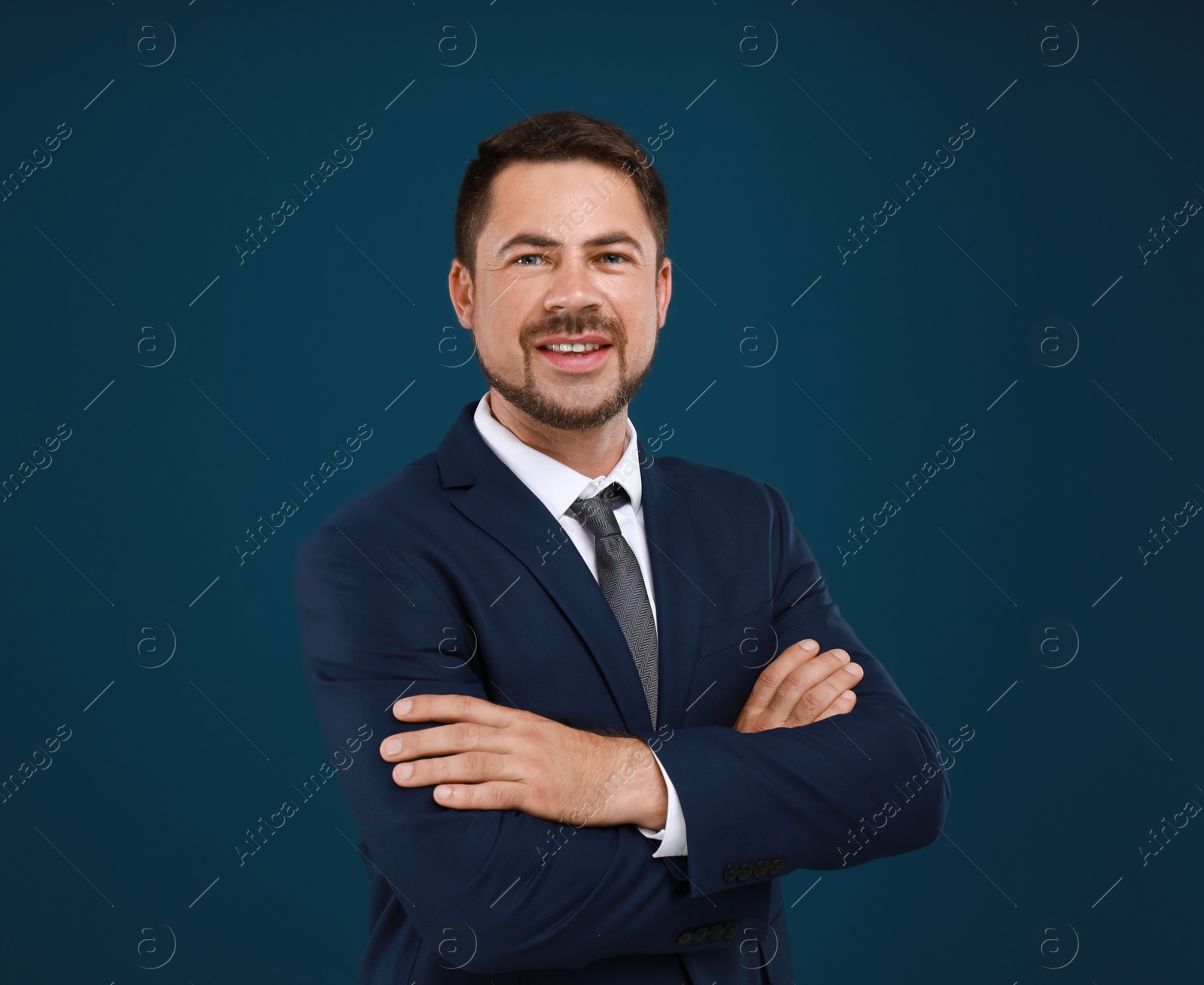 Photo of Portrait of handsome man in suit on blue background