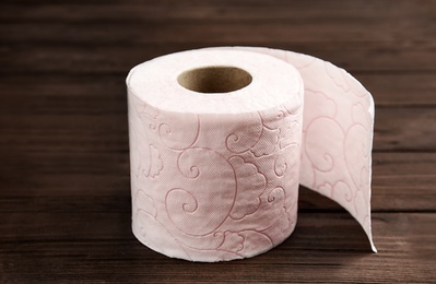 Photo of Toilet paper roll on wooden background. Personal hygiene