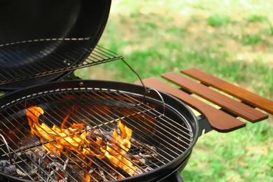 Photo of Modern barbecue grill with fire flames outdoors, closeup