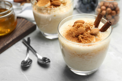 Delicious rice pudding with almonds and cinnamon on  marble table, closeup