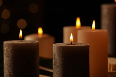 Photo of Closeup view of burning candles against blurred festive lights