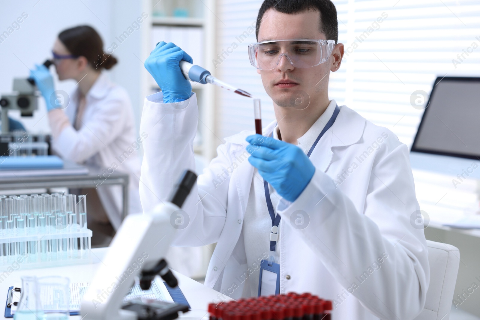 Photo of Scientist dripping sample into test tube in laboratory