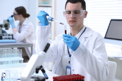 Scientist dripping sample into test tube in laboratory