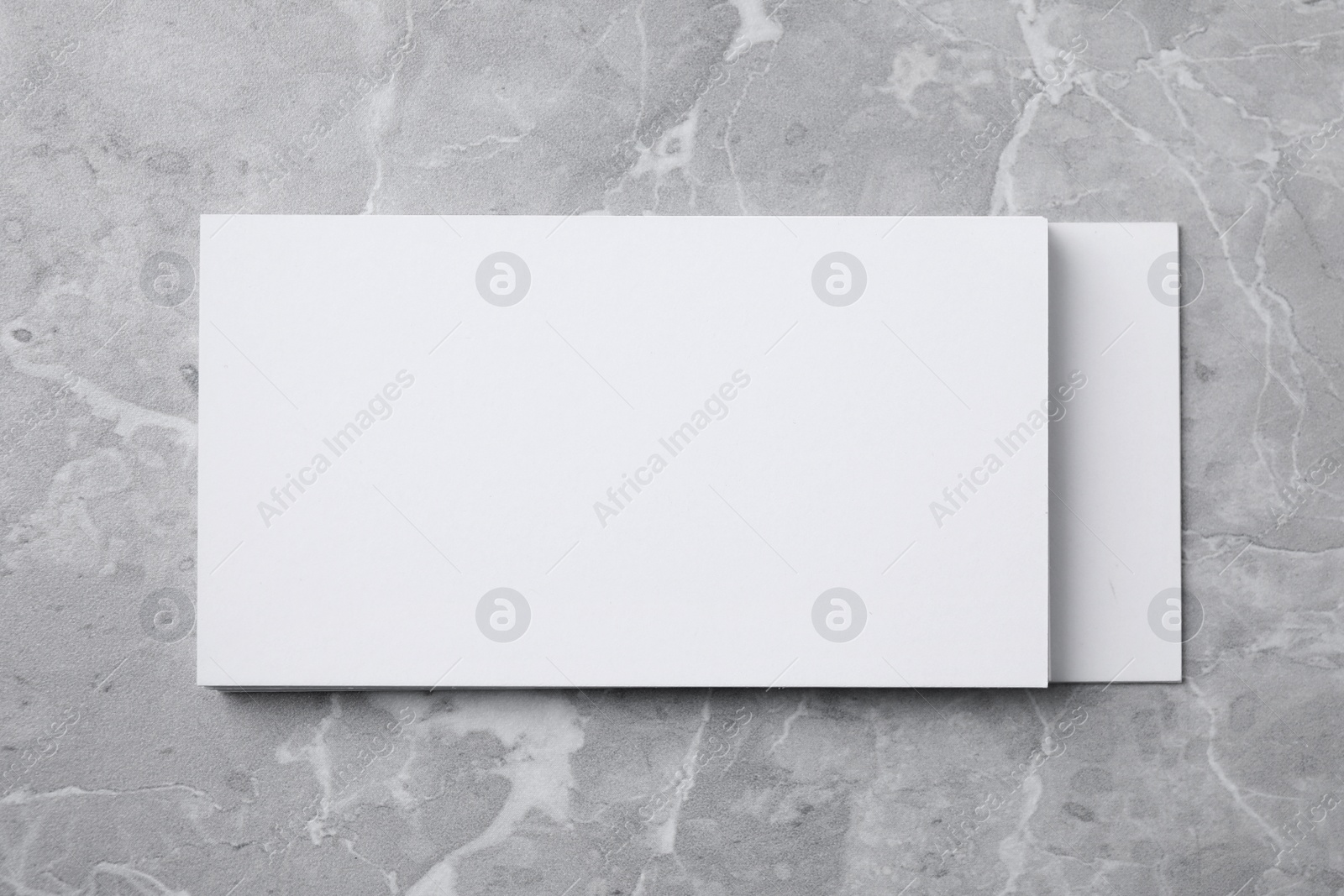 Photo of Stack of empty sheets on grey marble table. Mock up for design