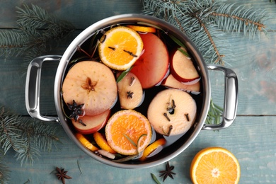 Tasty mulled wine with spices on blue wooden table, flat lay