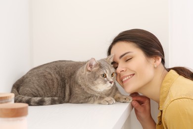 Photo of Young woman with adorable cat at home