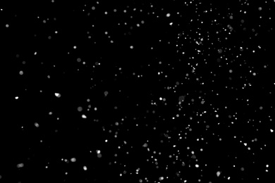 Photo of White snow falling down on black background