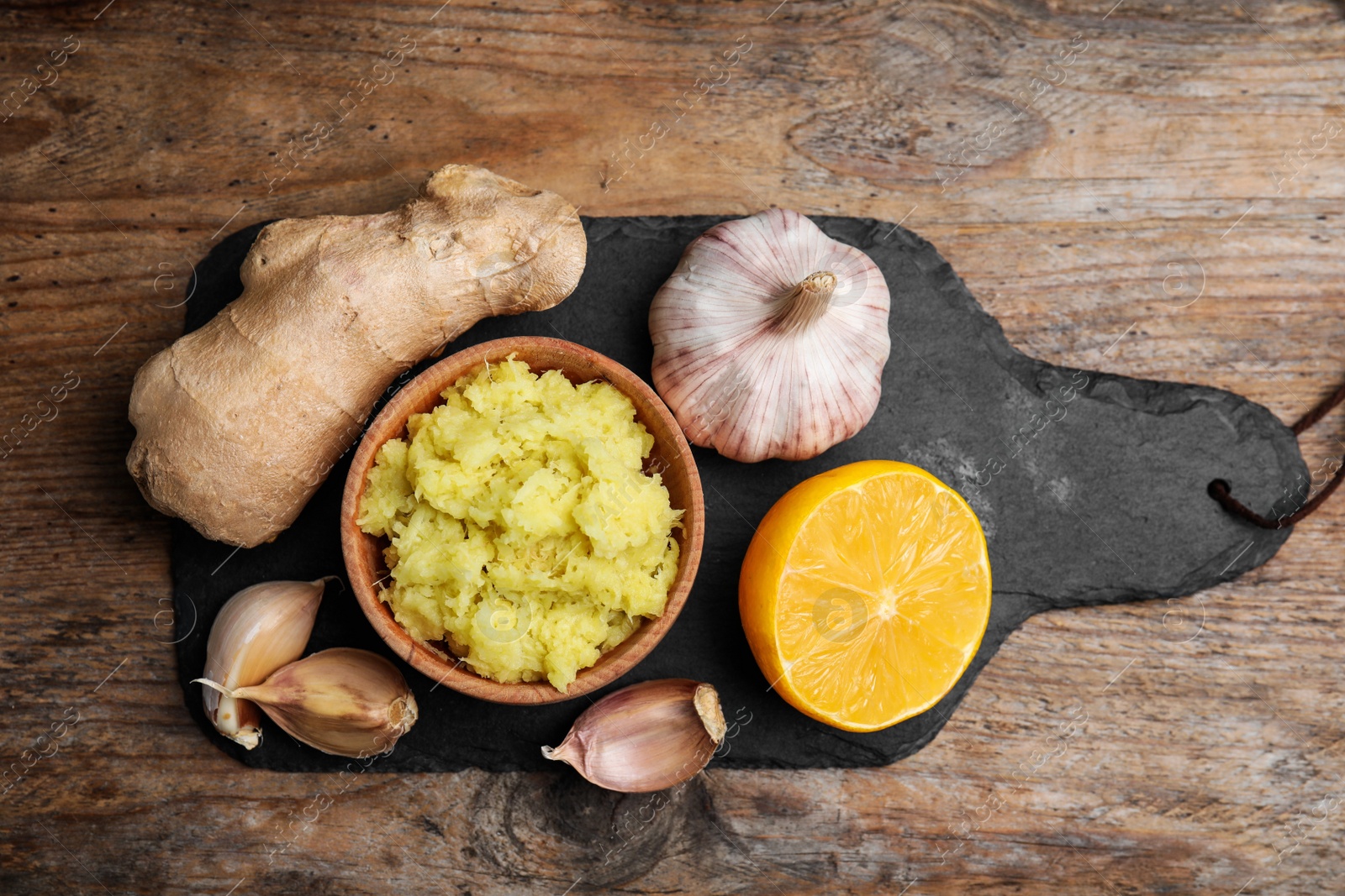 Photo of Fresh garlic and other natural cold remedies on wooden table, top view