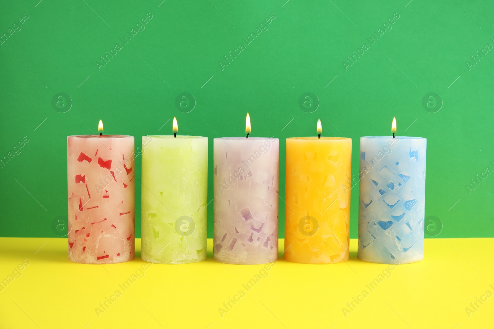 Photo of Alight scented wax candles on color background