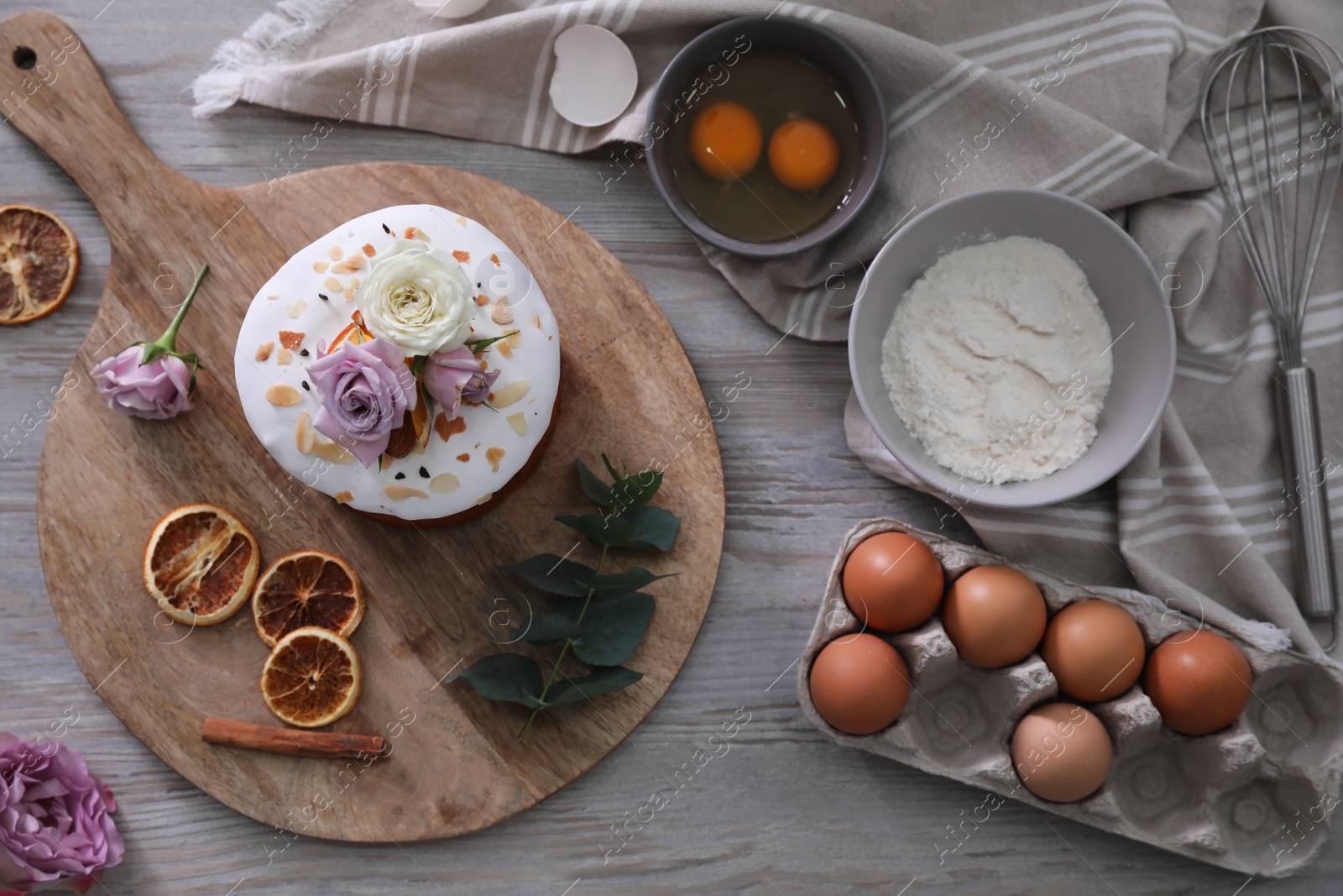 Photo of Flat lay composition with Easter cake and ingredients on light grey wooden table