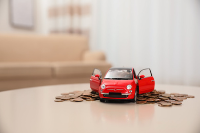 Photo of Miniature automobile model and money on table indoors. Car buying