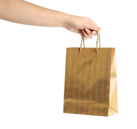 Woman holding golden paper shopping bag on white background, closeup. Space for design