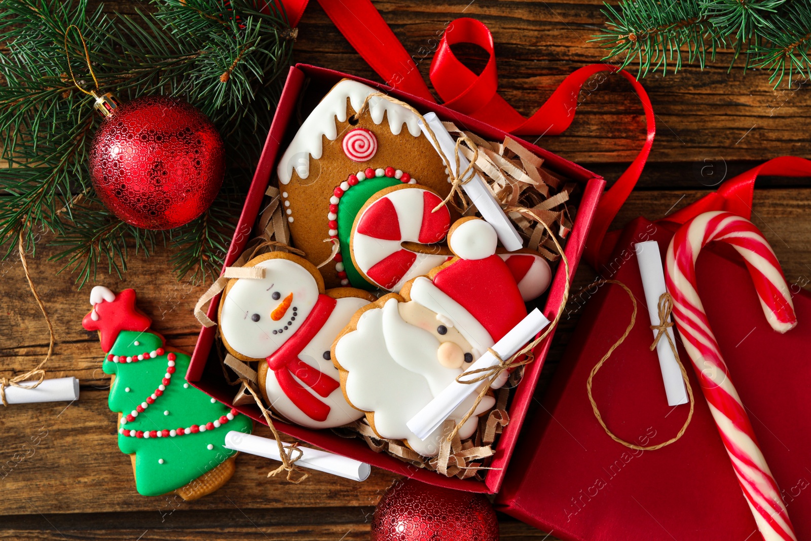 Photo of Christmas cookies in gift box and festive decor on wooden table, flat lay. Advent calendar