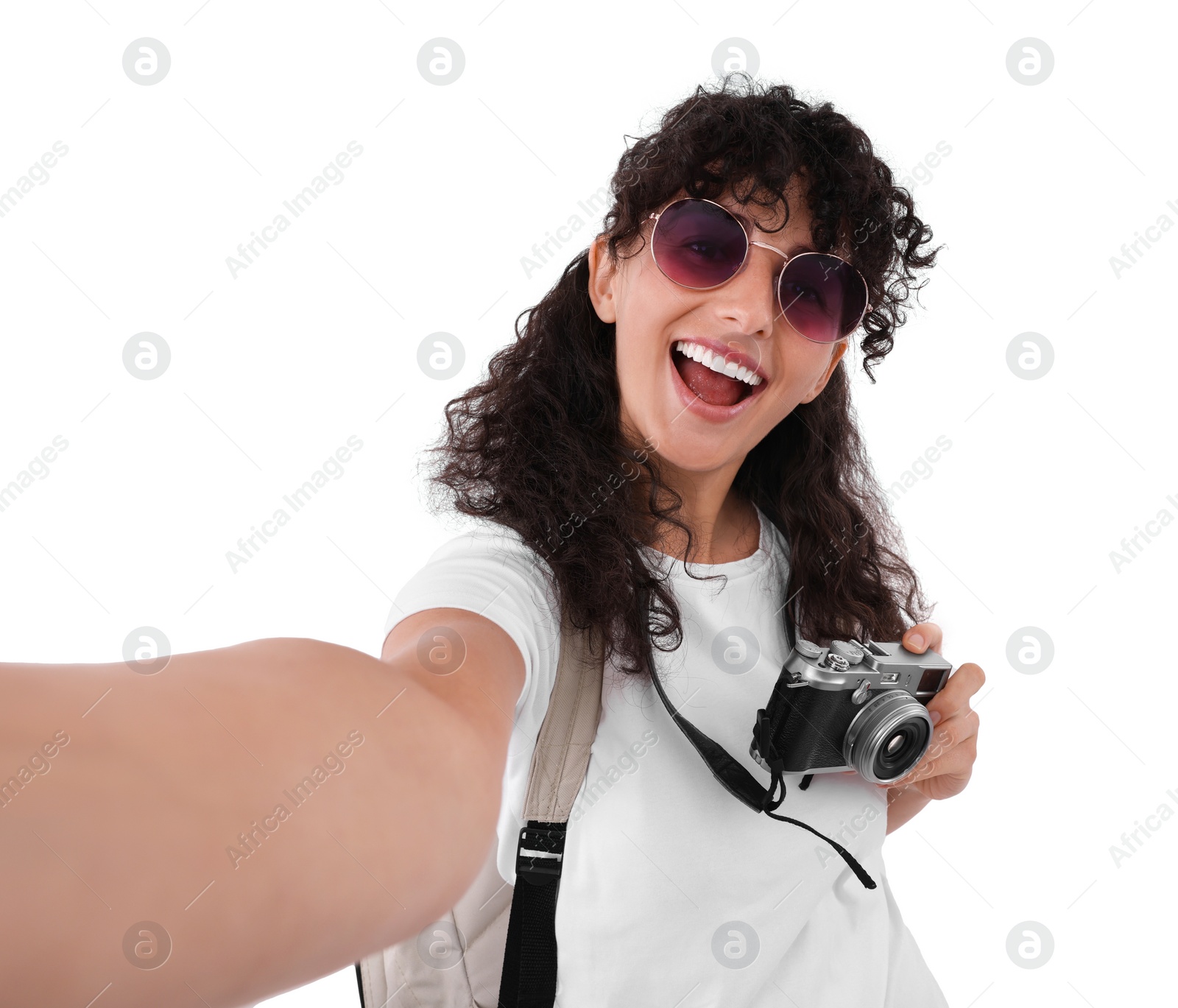 Photo of Beautiful woman in sunglasses with camera taking selfie on white background