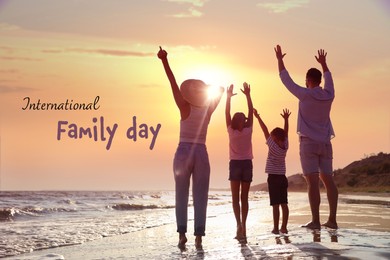 Image of Happy parents and their children on sandy beach near sea at sunset, back view. Happy Family Day