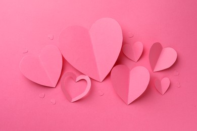 Paper hearts on pink background, flat lay