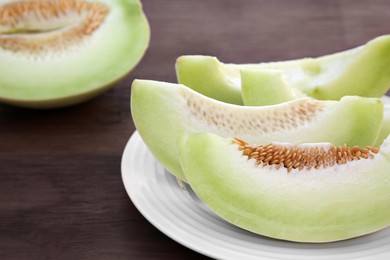 Photo of Cut tasty ripe melon on wooden table. Space for text