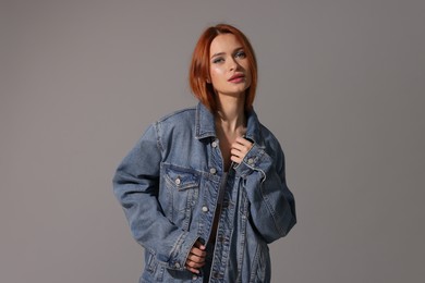 Photo of Beautiful young woman in denim jacket on gray background