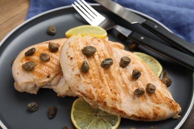 Delicious chicken fillets with capers and lemon on plate, closeup